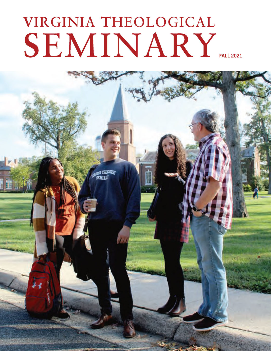 Four students stand in on the Grove of Virginia Seminary. Immanuel Chapel rises behind them.